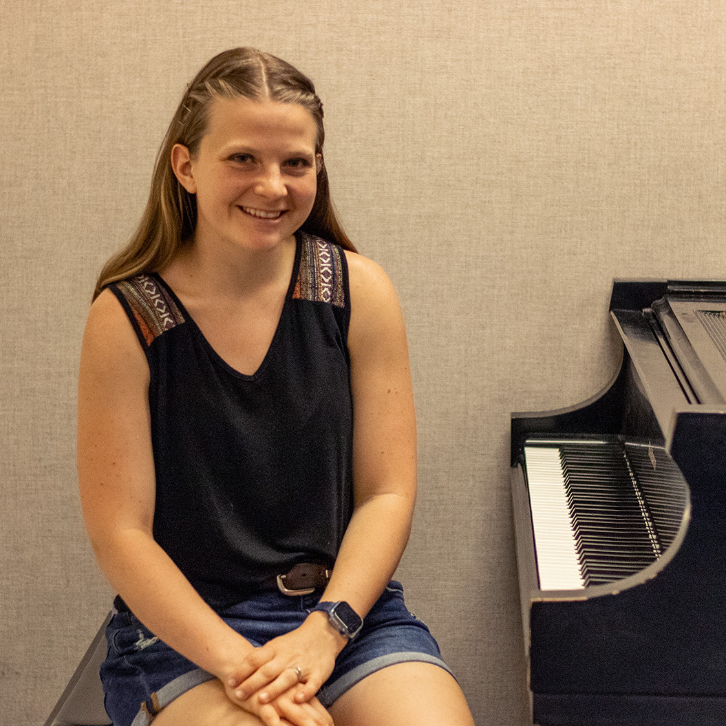 Close-up of a student sitting next to her practice piano.