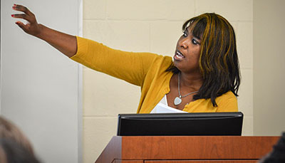 Professor giving a lecture in front of her classroom.