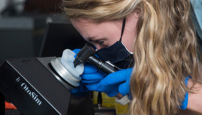 Person looking through a microscope.