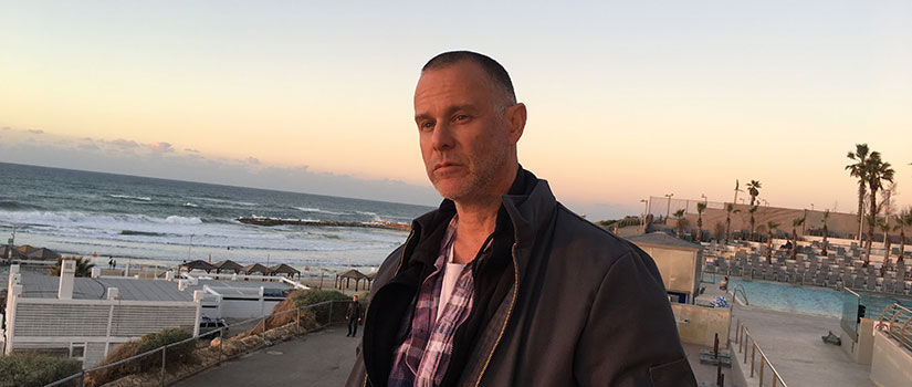 Michael Goldstone, president of Mom + Pop Music Company, stands on an overlook at the ocean.